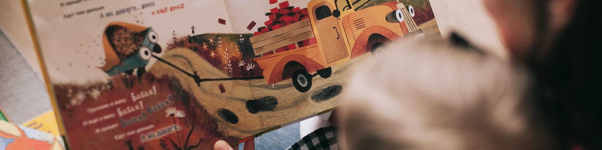 child reading book with adult